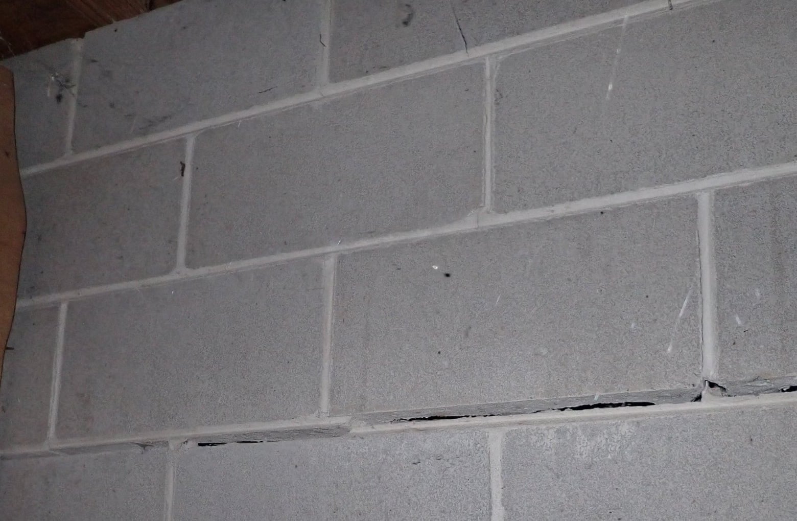 Wider view of horizontal separation and displacement in a concrete-block foundation wall