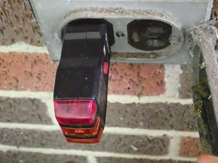 A receptacle tester plugged into an older worn three-prong outlet reading open ground